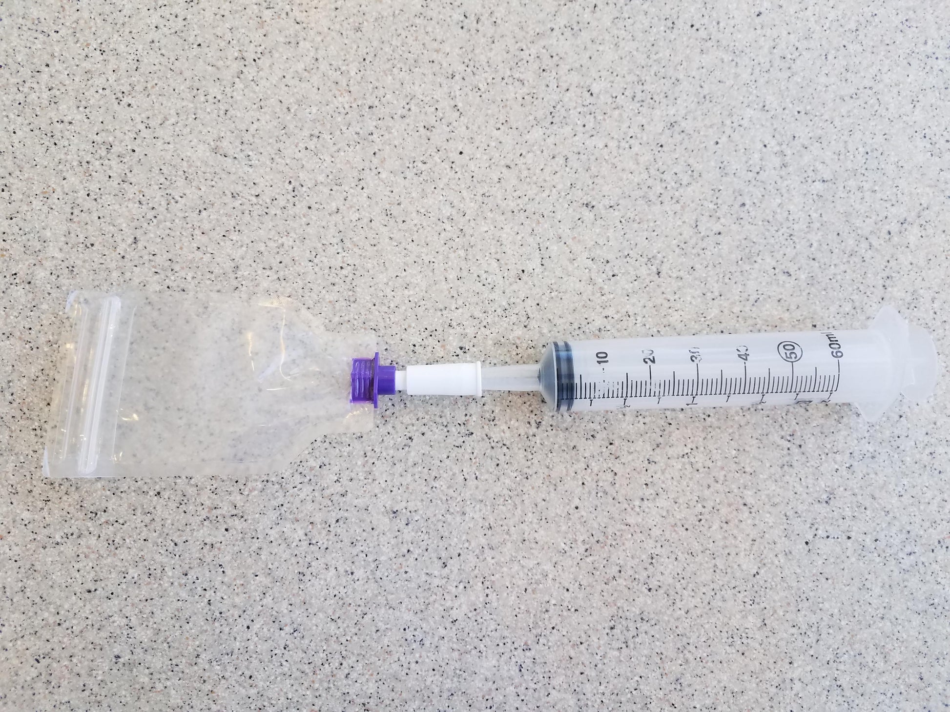 Female ENFit to Female Catheter Adapter Connected to Pill Pouch on One Side and Syringe to the Other